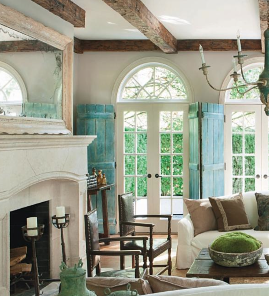 A limestone fireplace, crusty painted shutters and long, lean upholstery all make magic in this room. House Beautiful and Pinterest.