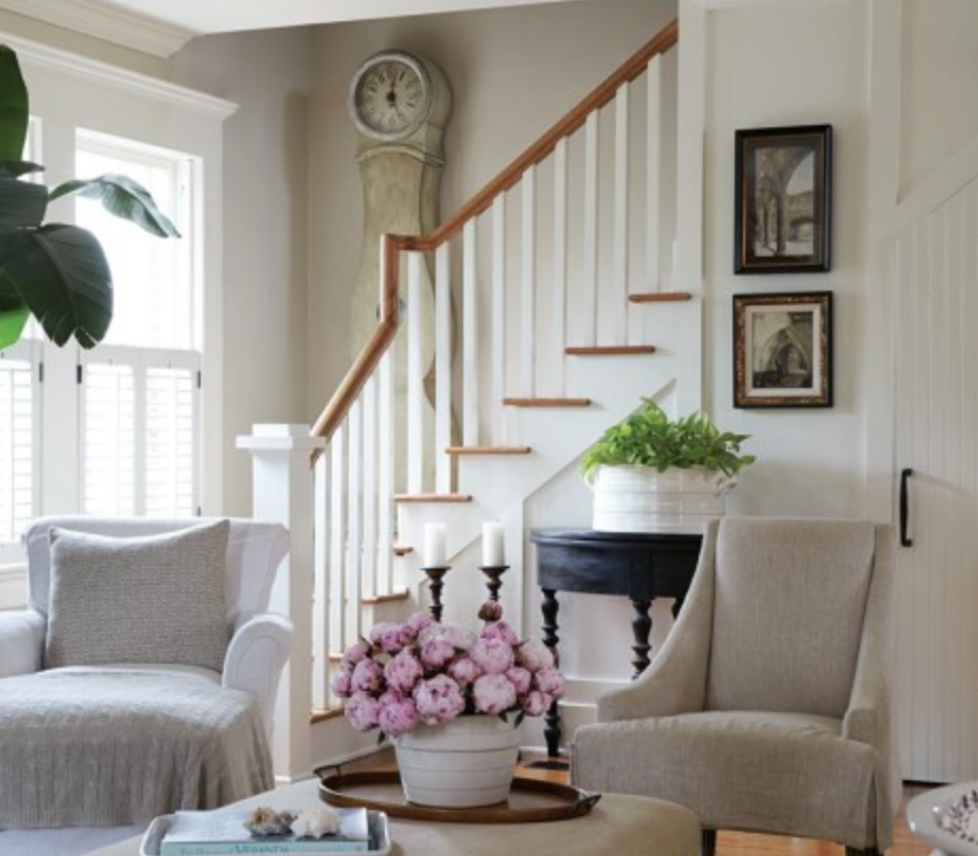 From Atlanta Homes and Lifestyles: the Mora clock sits in a perfect spot on a staircase and surrounded by a lovely mix of antiques, upholstery and art.