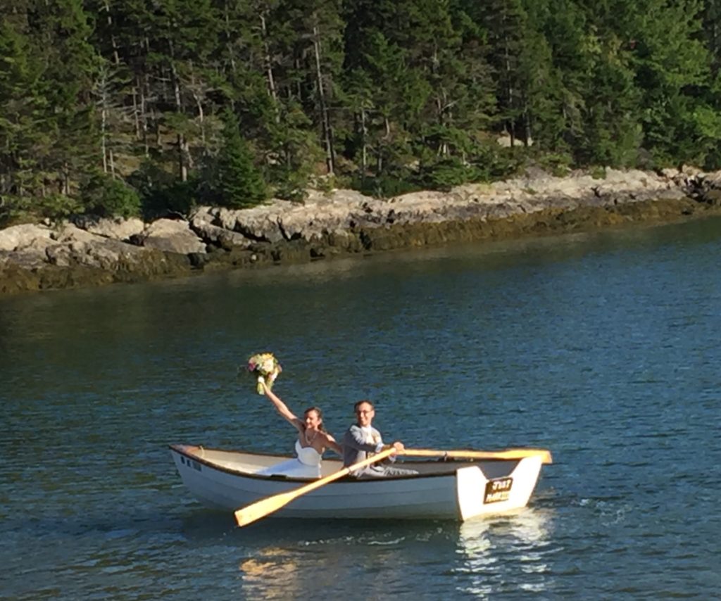 The bride and groom row into the sunset