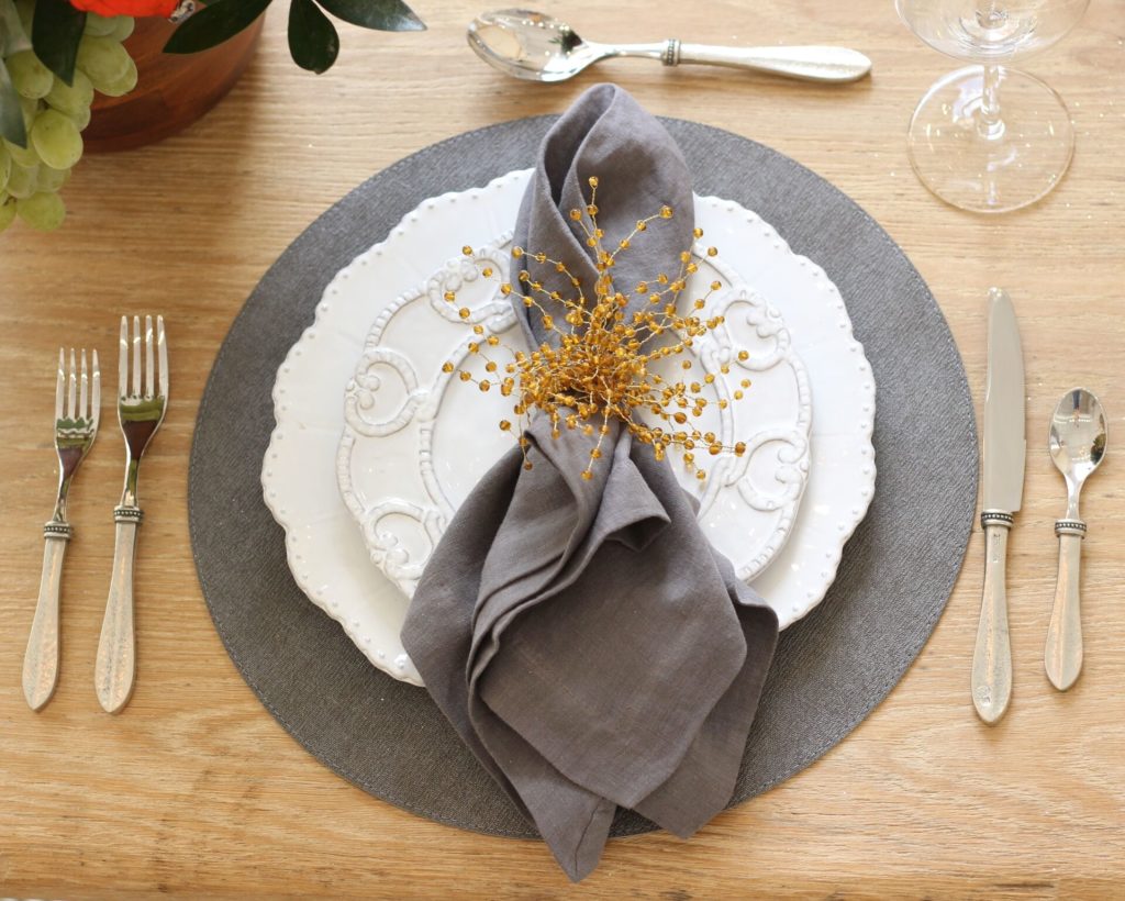 Arte Italica charger, Arte Italica dinner plate, charcoal napkin and placemat, beaded napkin ring and Arte Italica flatware.